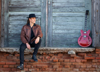 Peter Kern auf Presse-Foto mit roter Gitarre